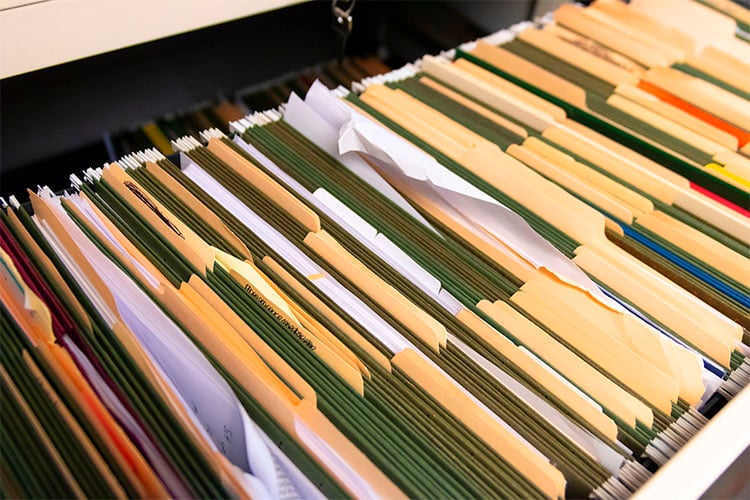 A file cabinet full of messy documents.